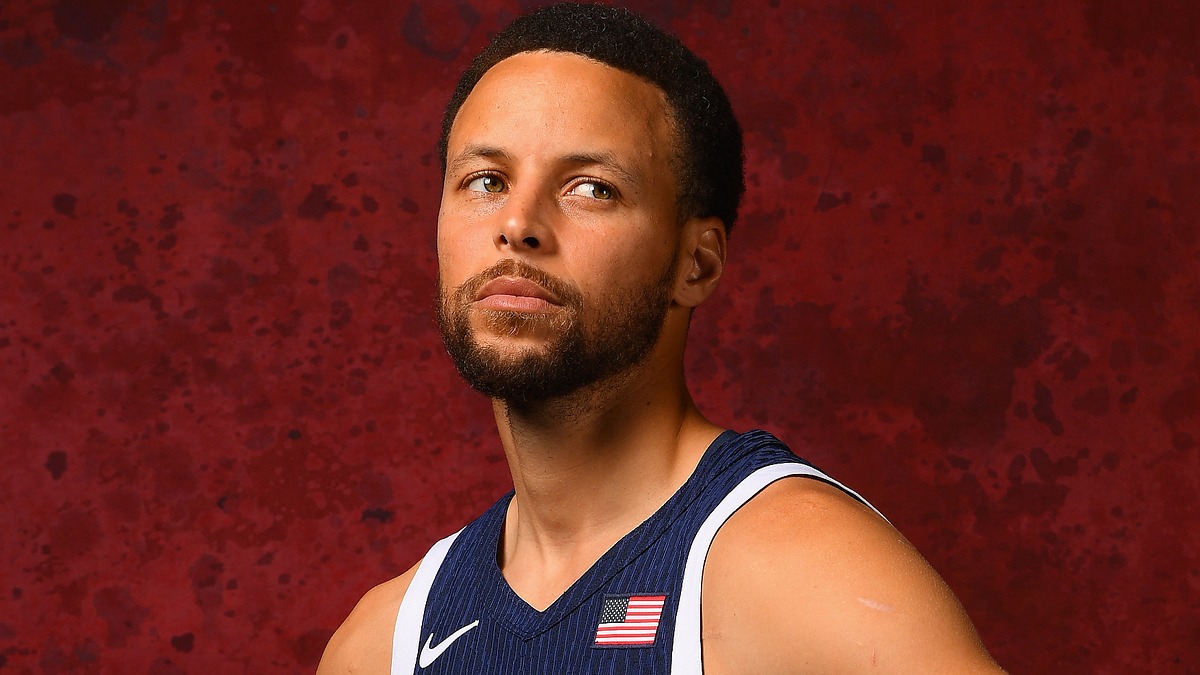 Stephen Curry poses in a sleeveless sports jersey with an American flag patch