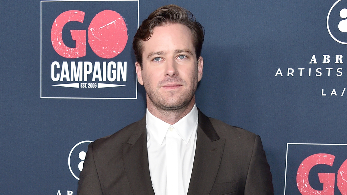 A man stands in front of a "GO Campaign" backdrop. He is dressed in a dark suit and white shirt