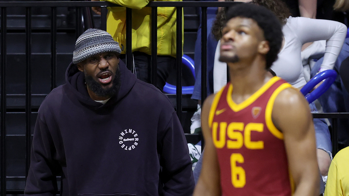LeBron James is shouting from the sidelines while Bronny James, in USC basketball uniform number 6, is on the court