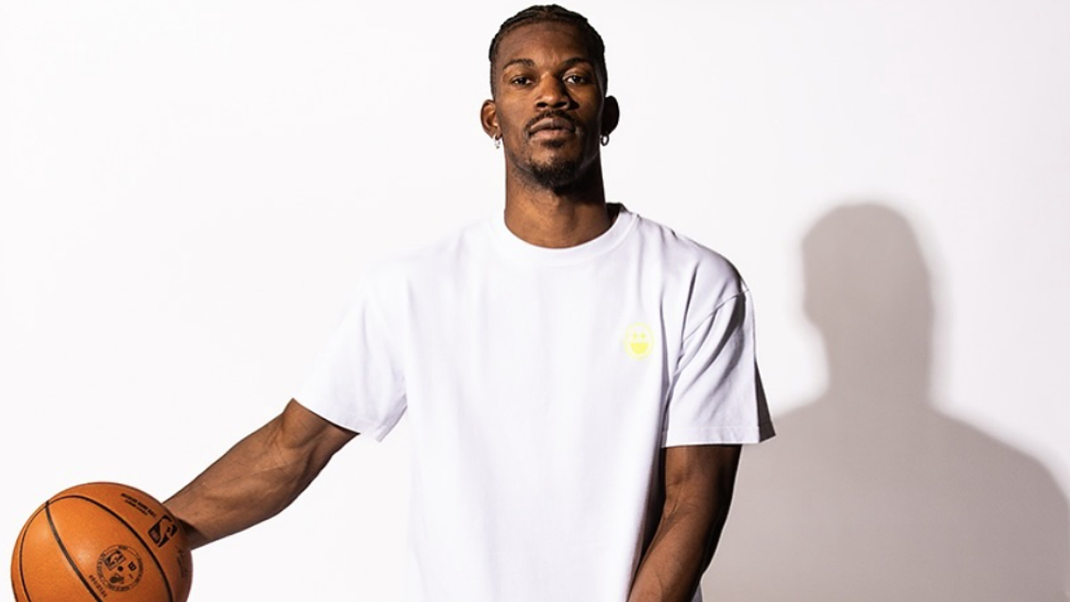 Basketball player in a plain T-shirt holds a basketball, posing for a sports photoshoot