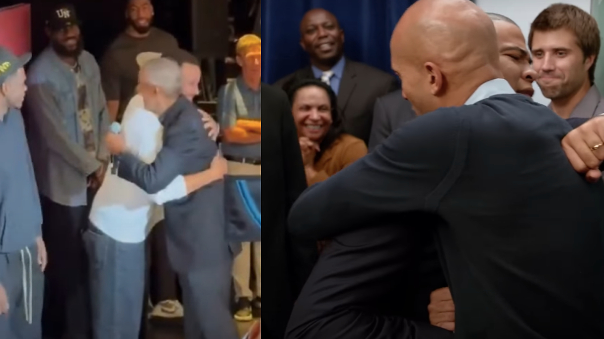 Barack Obama hugs on a stage, while people around them look on and smile