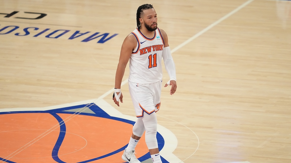 Jalen Brunson in a New York Knicks uniform walking on the basketball court at Madison Square Garden during a game