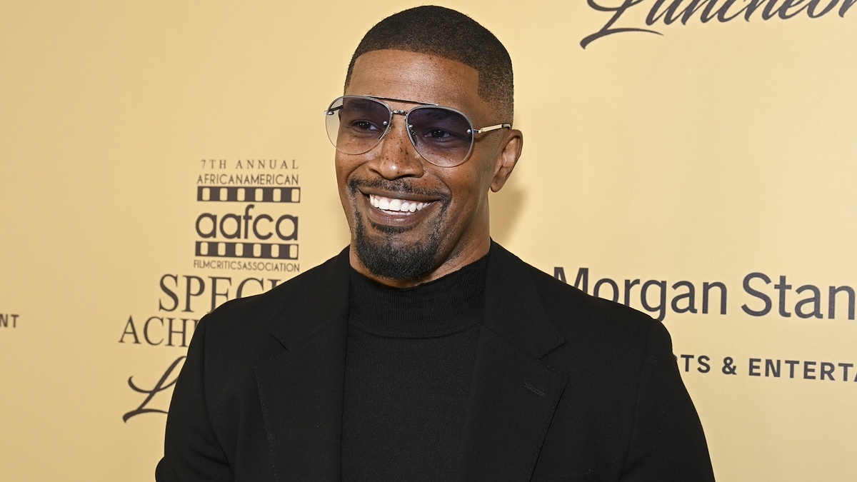 Jamie Foxx at the 7th Annual African American Film Critics Association Special Achievement Luncheon, wearing a black outfit and sunglasses, smiling