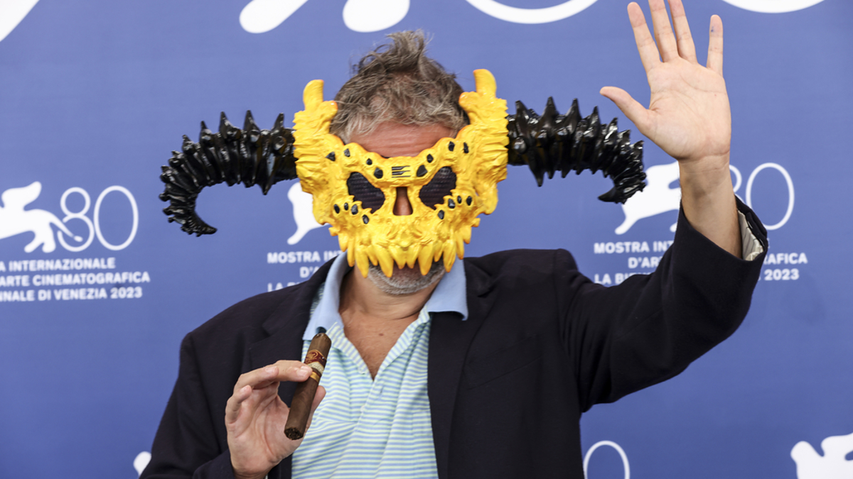 Del Toro wears a unique horned mask and waves while holding a cigar at the 80th Venice Film Festival