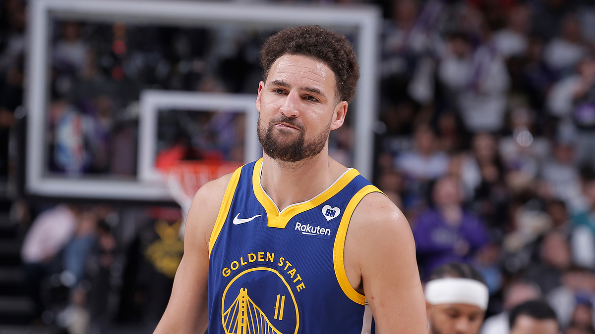Klay Thompson of the Golden State Warriors in a basketball arena, wearing his team jersey