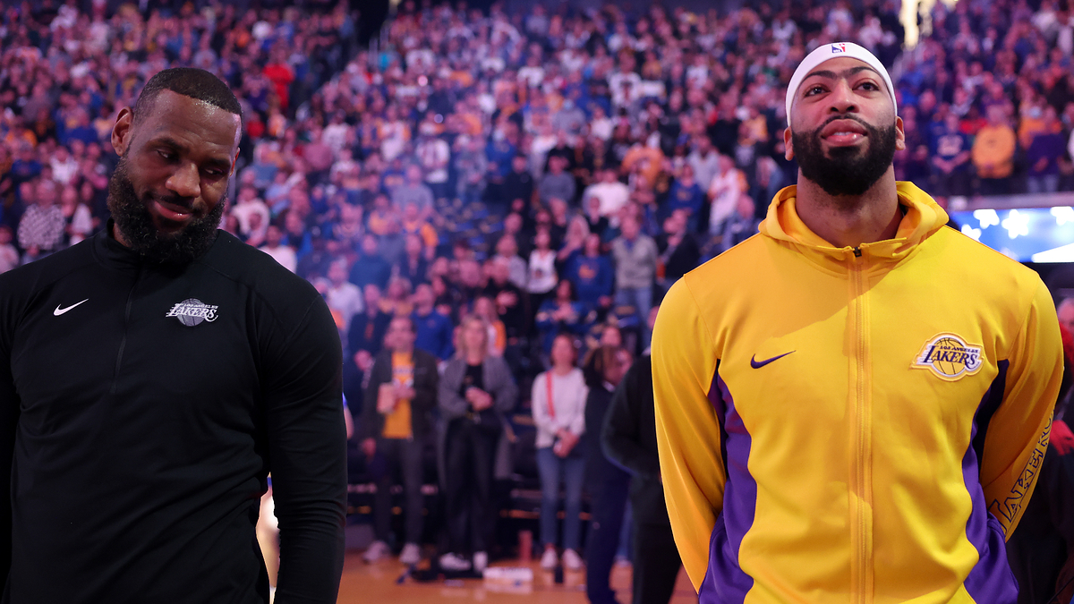 LeBron James and Anthony Davis stand on the basketball court during a game, with a crowd in the background