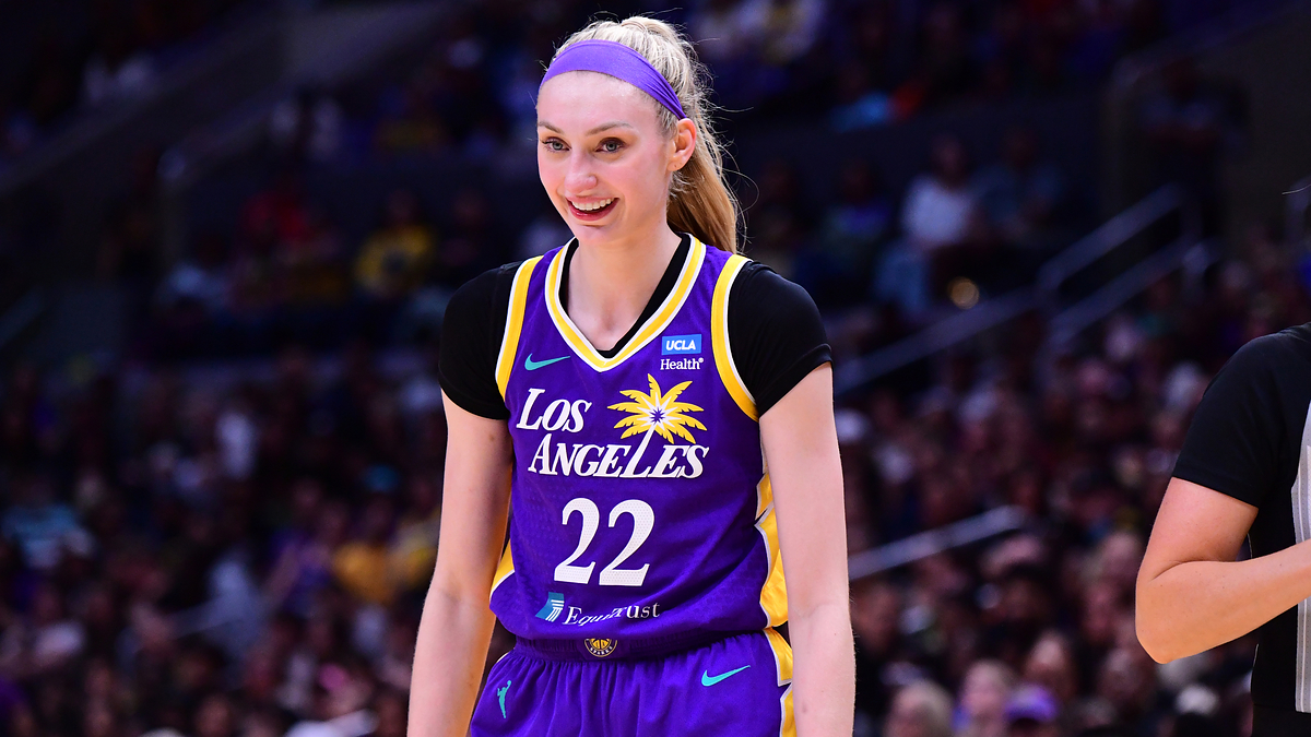Basketball player smiles on the court, wearing a Los Angeles jersey with number 22