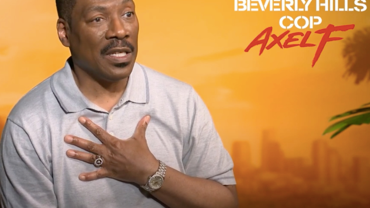 Eddie Murphy, in a short-sleeve polo, gesturing with one hand during an interview for "Beverly Hills Cop: Axel F."
