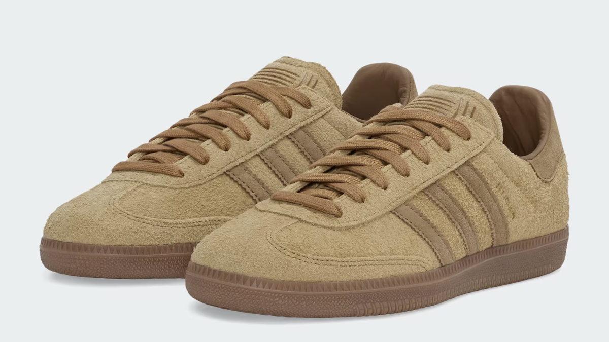 A pair of beige suede Adidas Gazelle sneakers with brown detailing and laces, displayed on a light background