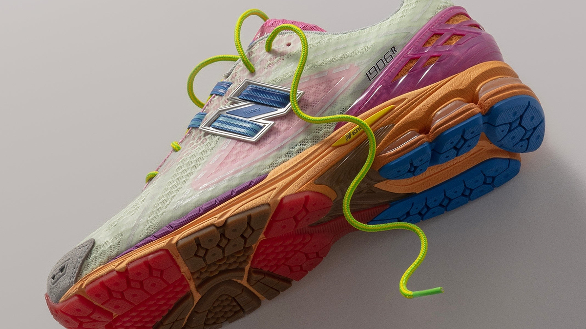 A close-up shot of a New Balance sneaker with a complex, multicolored sole and a textured upper, highlighted by contrasting bright laces
