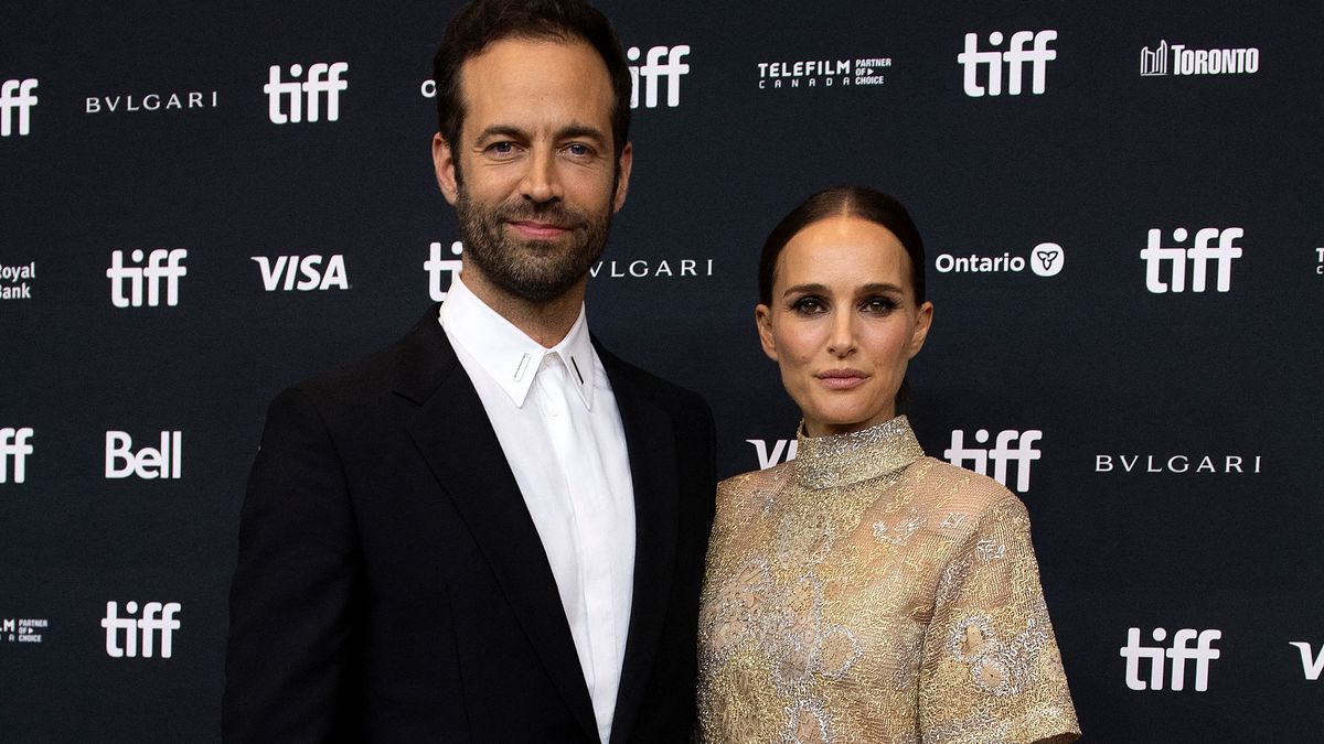 Benjamin Millepied and Natalie Portman pose together on the red carpet at the Toronto International Film Festival. Millepied wears a suit, Portman a chic dress