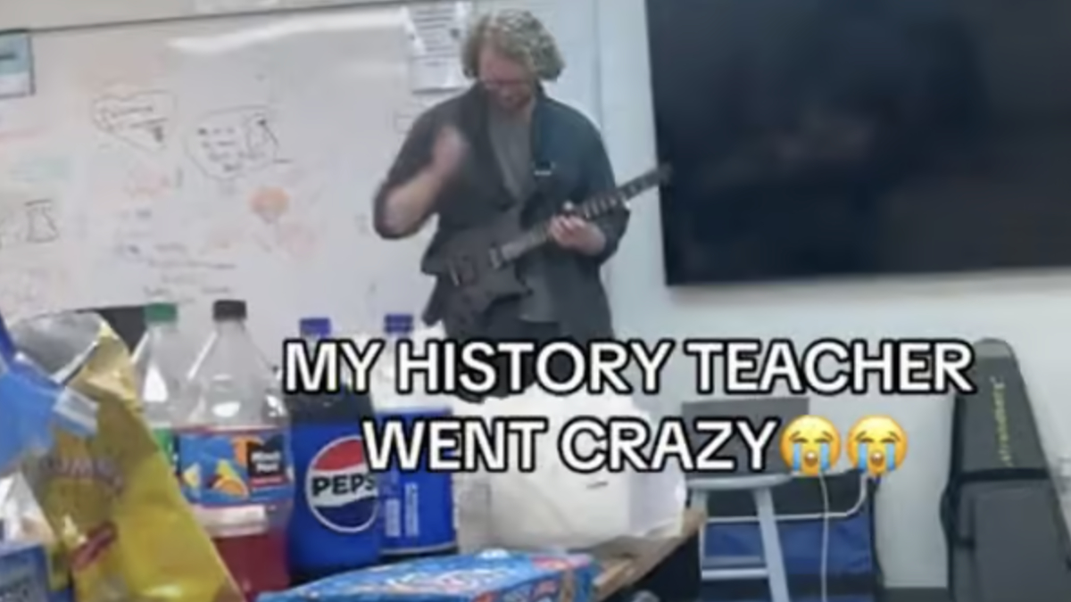 A teacher in a classroom strums an electric guitar. The whiteboard behind him has various drawings. Overlay text reads, "MY HISTORY TEACHER WENT CRAZY ??."