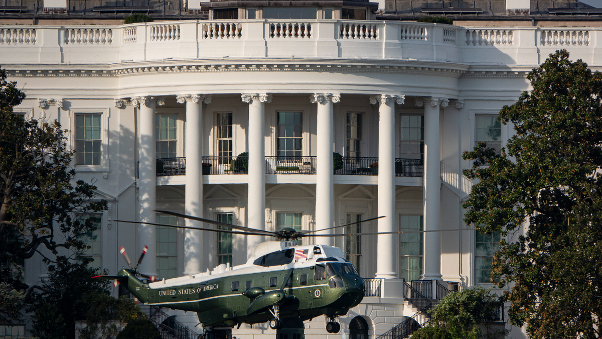 A helicopter labeled "United States of America" is stationed in front of the White House