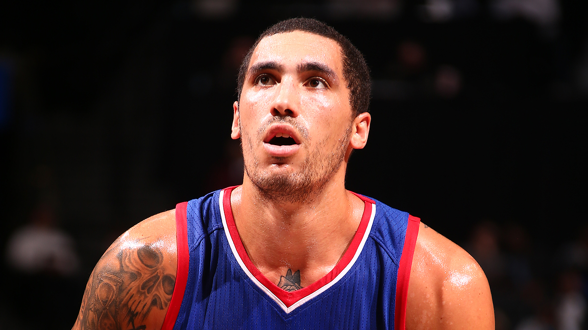 Man in a basketball jersey with tattoos on his right arm looking upwards during a game. Name of the person not known