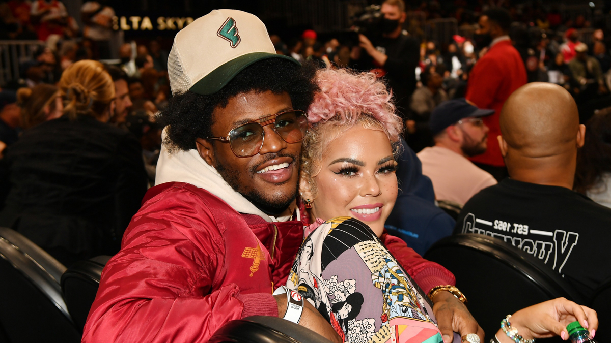 DC Young Fly and Ms Jacky Oh are seated together at a public event, smiling and posing for the camera