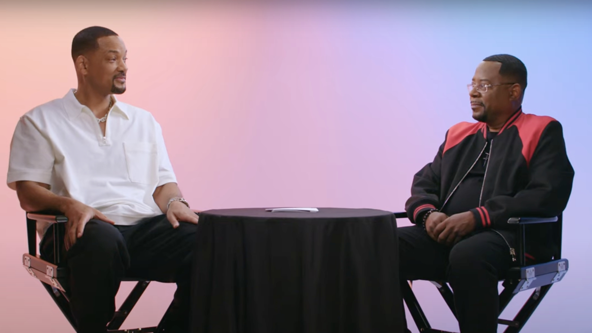 Will Smith and Martin Lawrence sit and talk across a table in a casual setting, possibly discussing music or a project