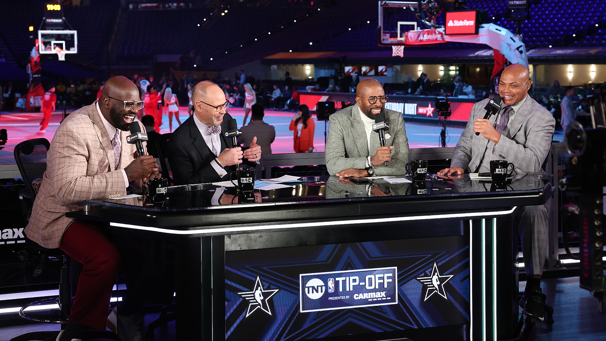 Shaquille O'Neal, Ernie Johnson, Kenny Smith, and Charles Barkley are discussing basketball at the "TNT Tip-Off" set, with a basketball court in the background