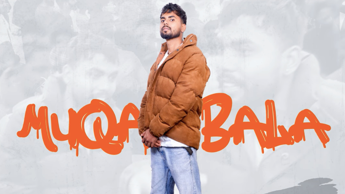 Man standing confidently with "MUQABLA" text, wearing stylish brown jacket, posing for music-related content