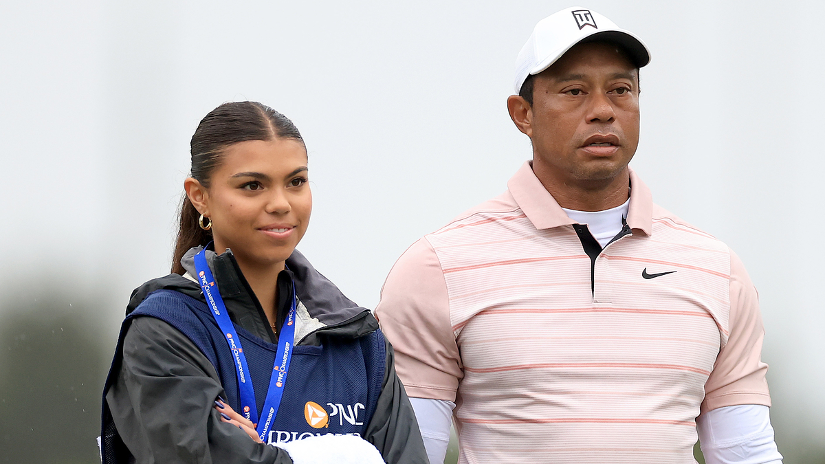 Two individuals, likely a father and daughter, standing side by side on a golf course