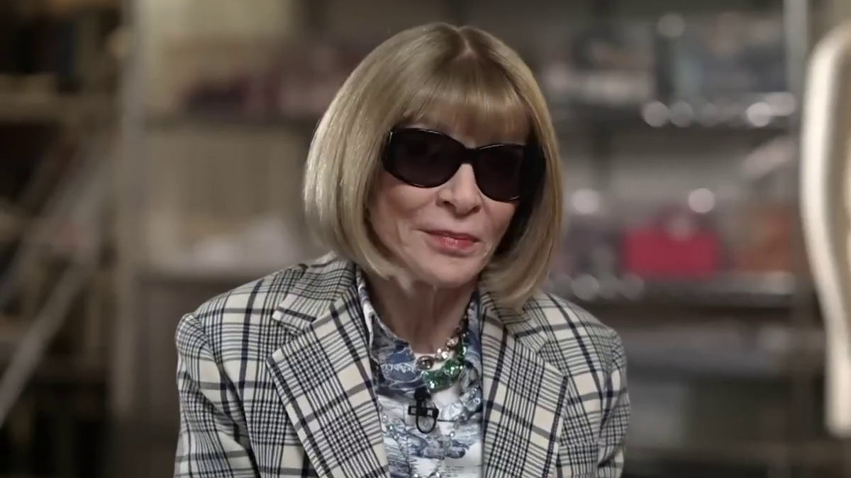 Woman in checked jacket and dark sunglasses with bob haircut