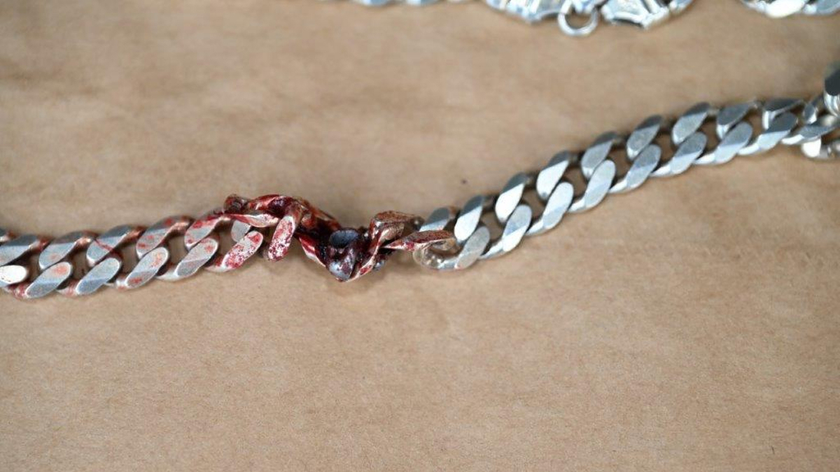 Close-up of a silver bracelet with one damaged, twisted link