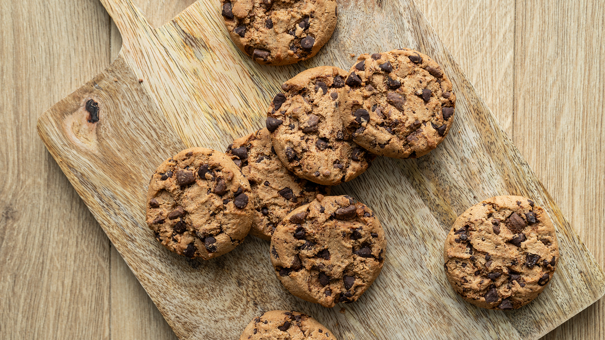 Cookies with chocolate chips arranged on a wooden cutting board