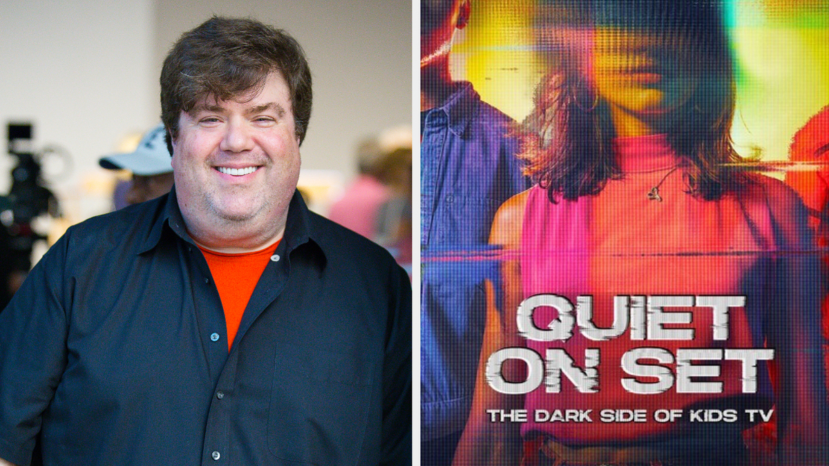 Smiling man in an orange shirt beside a promo poster for "Quiet On Set," a documentary on kids' TV