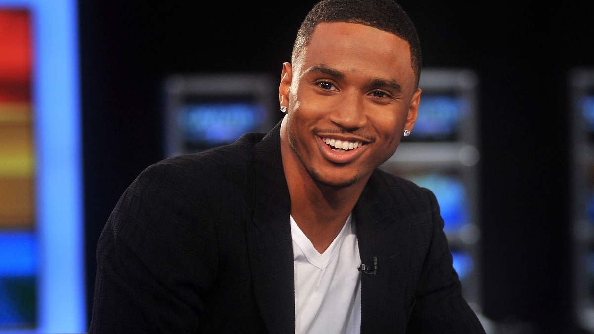 Smiling person seated, wearing a blazer over a shirt. They are engaged in an interview setting