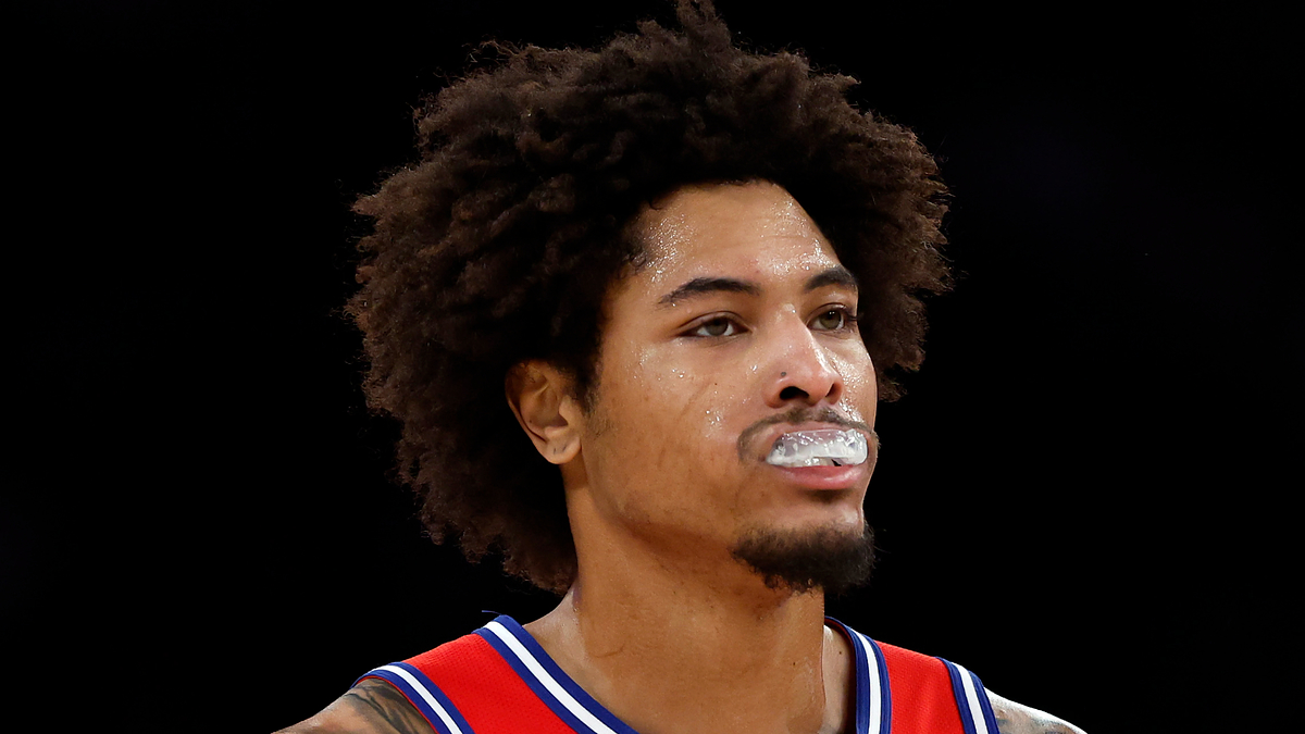 Basketball player on the court wearing mouthguard and team uniform, looking focused during a game