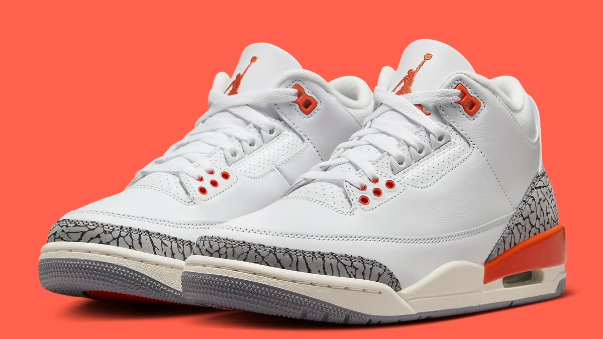 A pair of white Air Jordan 3 sneakers with orange accents and elephant print detailing