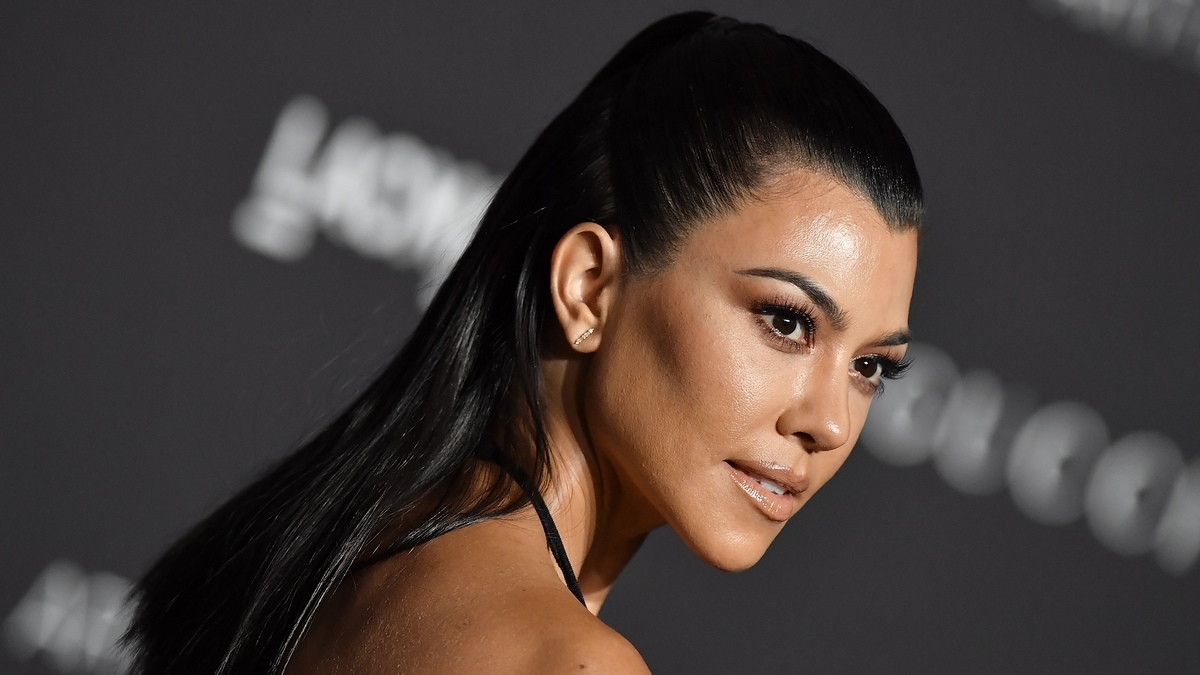Kim Kardashian in a sleek black outfit with her hair styled straight