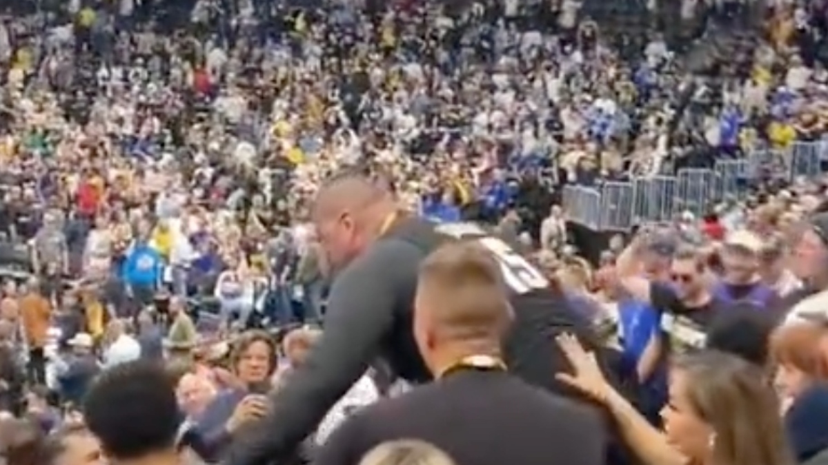 Crowd at a sports event with a person being lifted above others, possibly celebrating