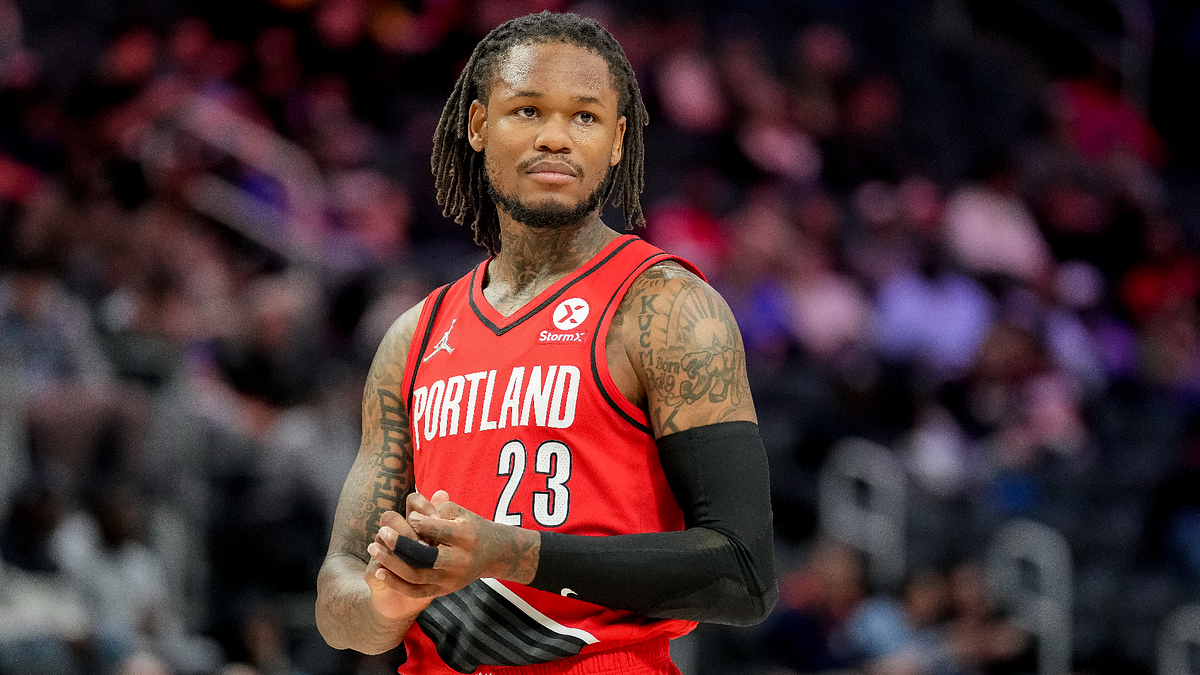 Basketball player on the court in a Portland uniform with the number 23, hands outstretched, expression focused