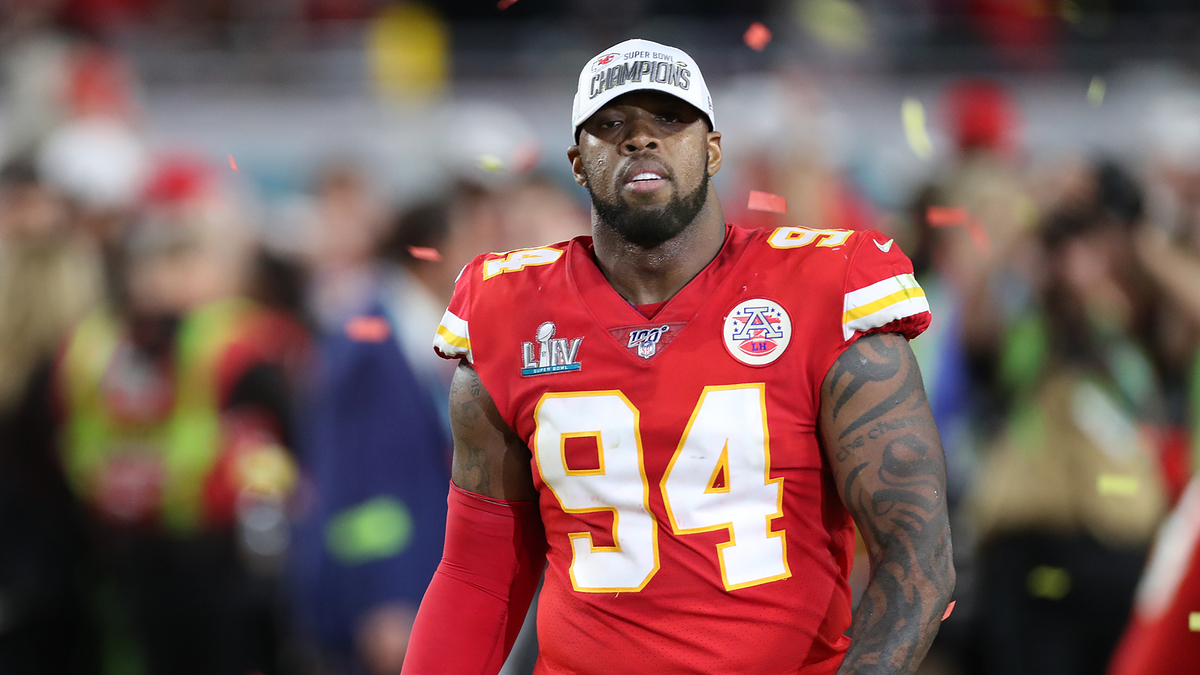 Kansas City Chiefs player in jersey number 94 on the field with "Champions" patch