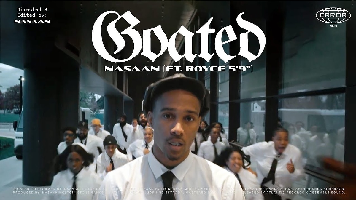 Music video scene with artist Nasaan and Royce 5'9" in formal white outfits, with a group around, in an urban setting