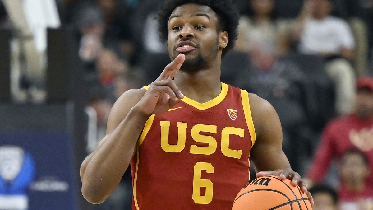 USC basketball player #6 in motion, gesturing while holding a basketball on the court