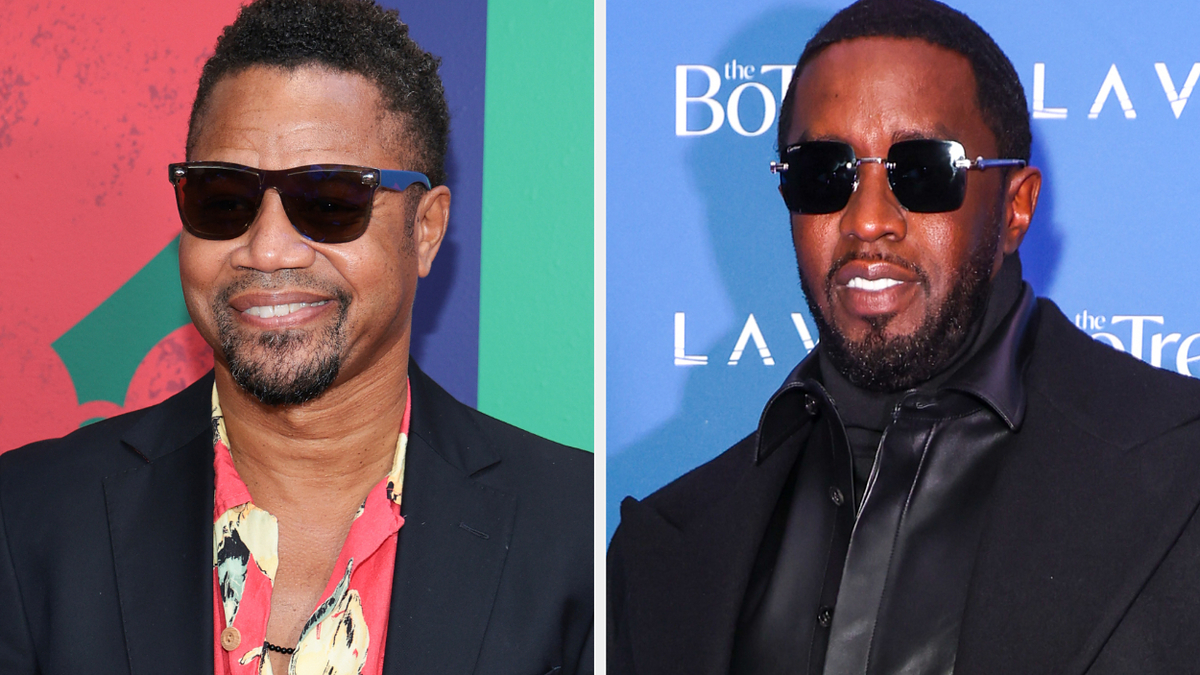 Two male celebrities at an event, one in a floral shirt and jacket, the other in a black outfit with sunglasses