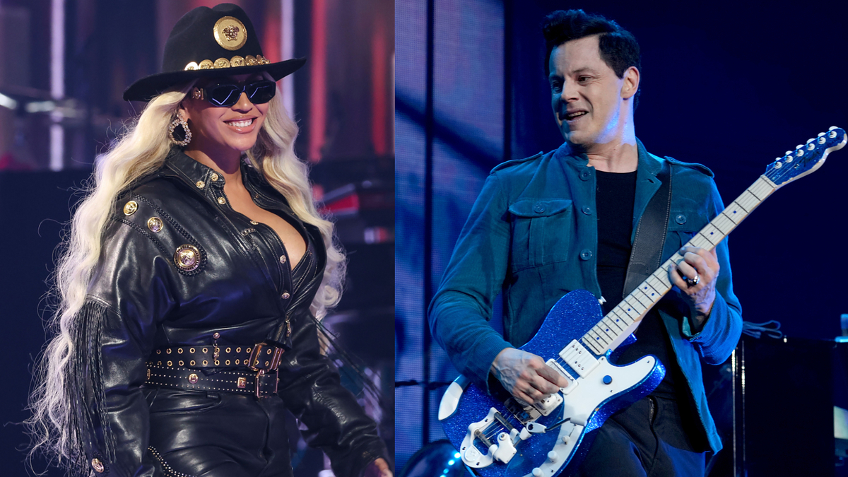 Two performers on stage; one in a black ensemble with a cowboy hat, the other plays a guitar