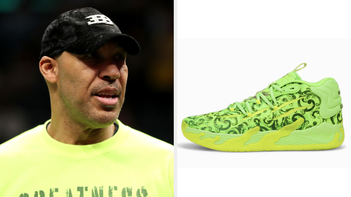 A person in a neon shirt with "GREATNESS" text and a neon yellow patterned sneaker