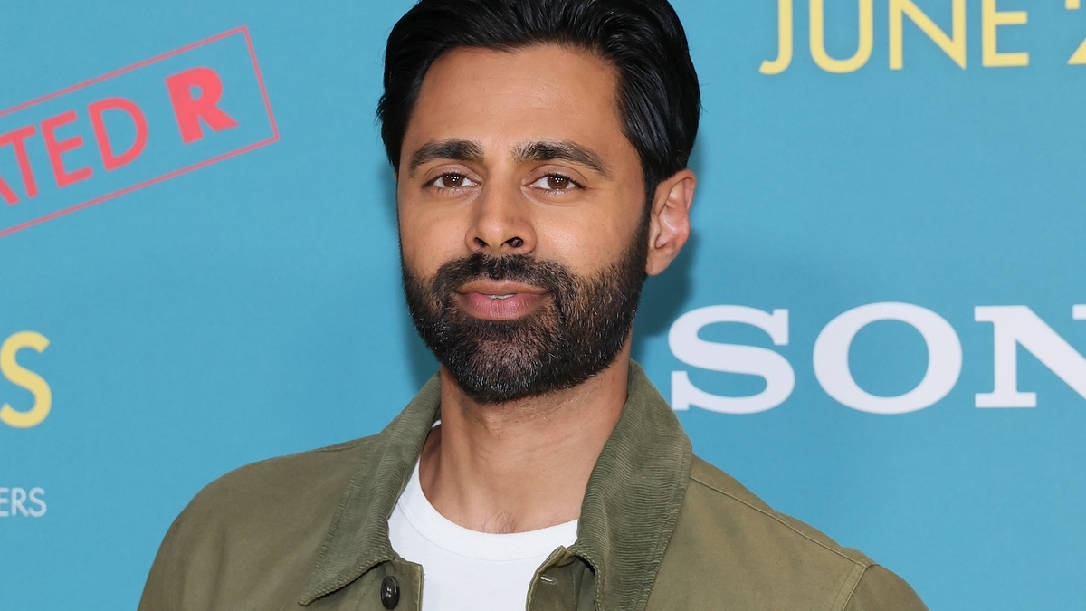 Man in a jacket posing at a Sony event with a promotional background