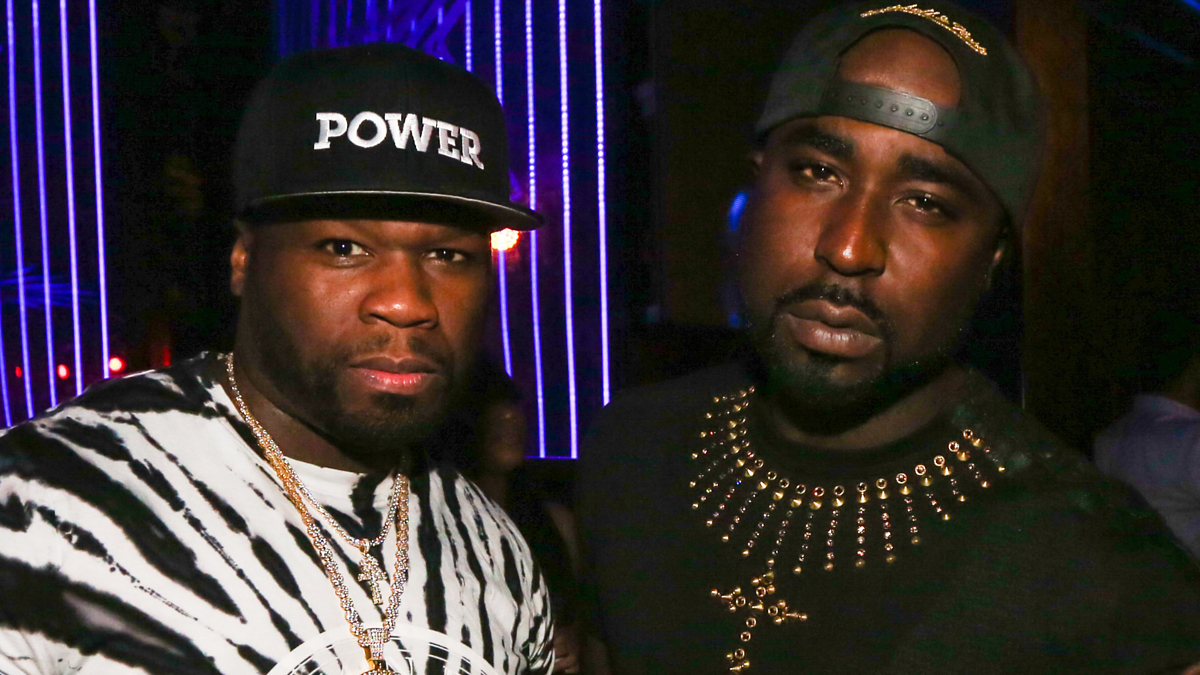 Two male artists in a club, one in hat with 'POWER' on it, the other in a studded shirt