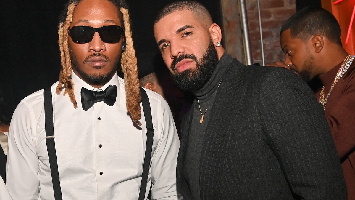 Two men in formal attire with one wearing a bow tie and the other a turtleneck at an event