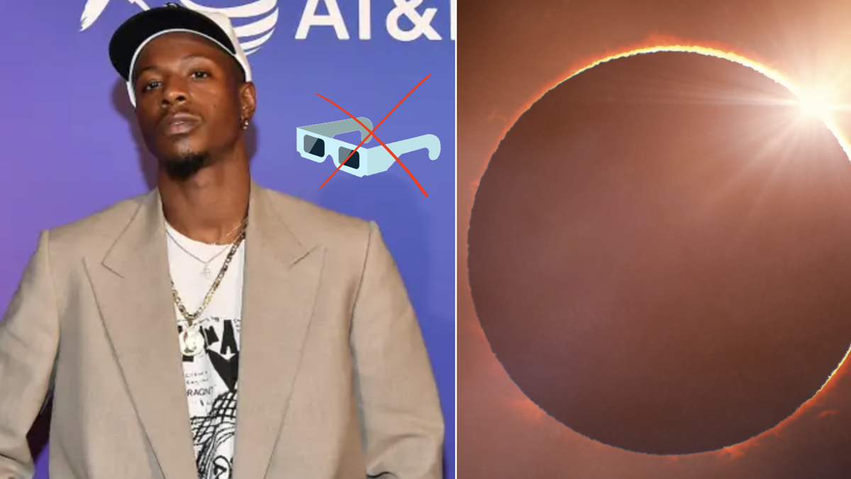 Man in blazer over graphic tee at music event, with a solar eclipse graphic on right side