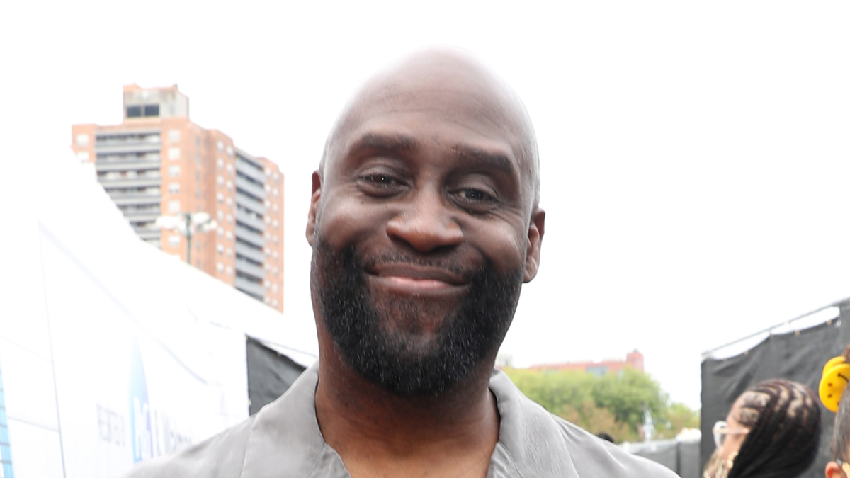 Man smiling at the camera wearing a gray suit