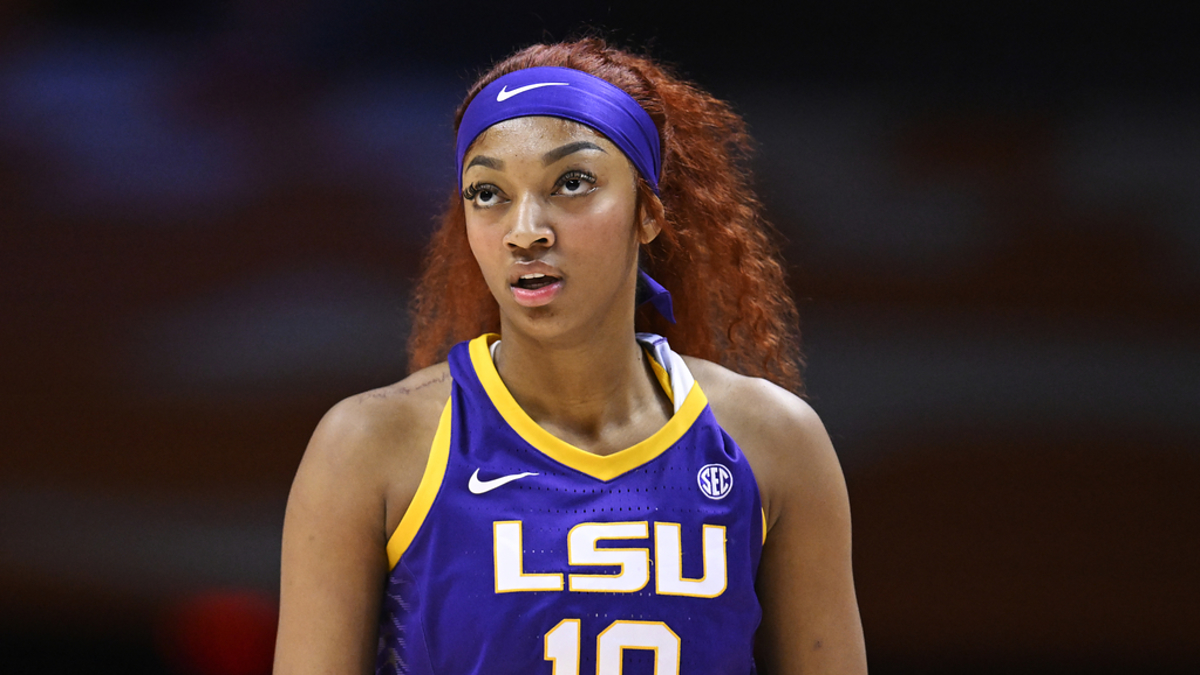 A female basketball player in an LSU jersey with the number 10 focused during a game