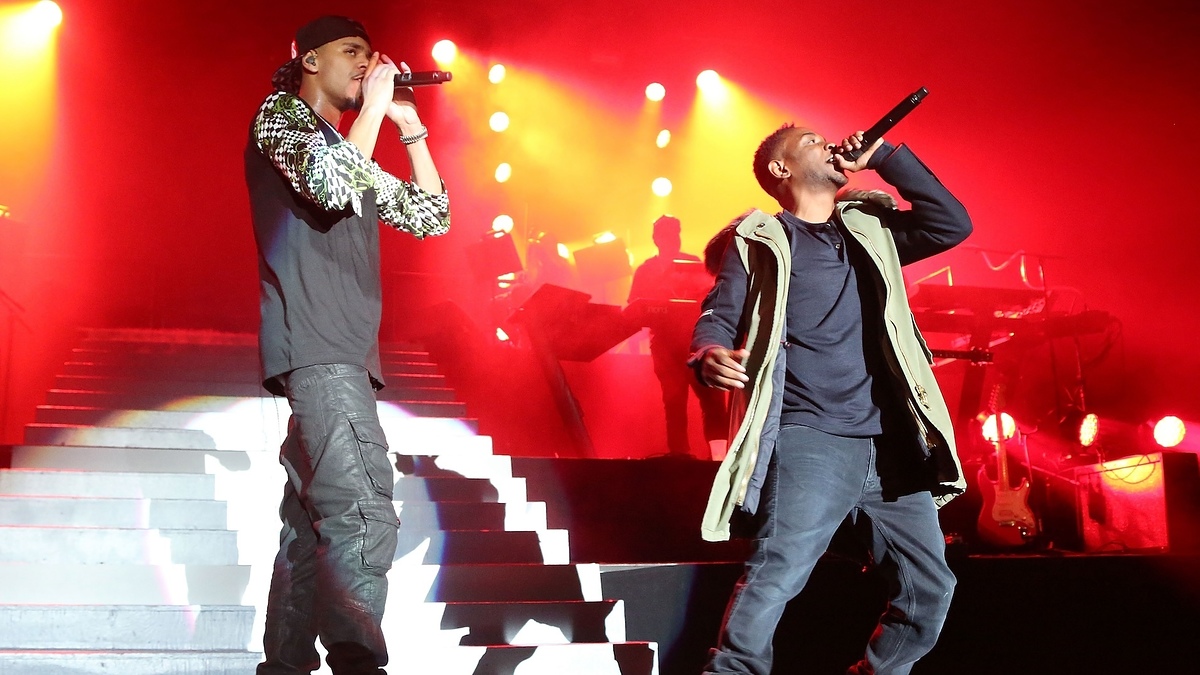 Eminem and Justin Timberlake perform on stage with a band in the background