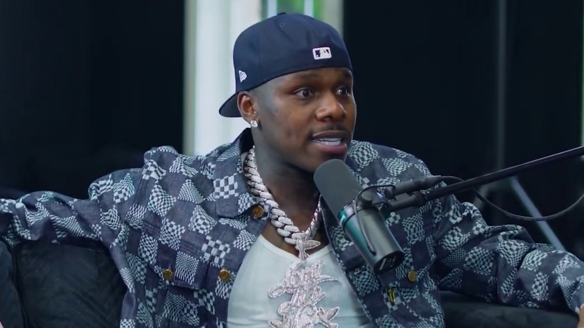 DaBaby wearing a patterned jacket in a podcast studio with a microphone