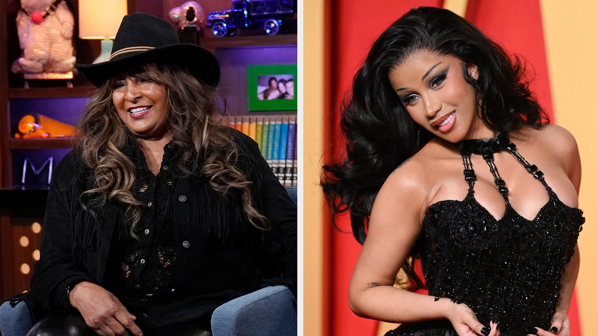 Two women on a talk show set; one wearing a hat and casual outfit, the other in a glamorous black dress