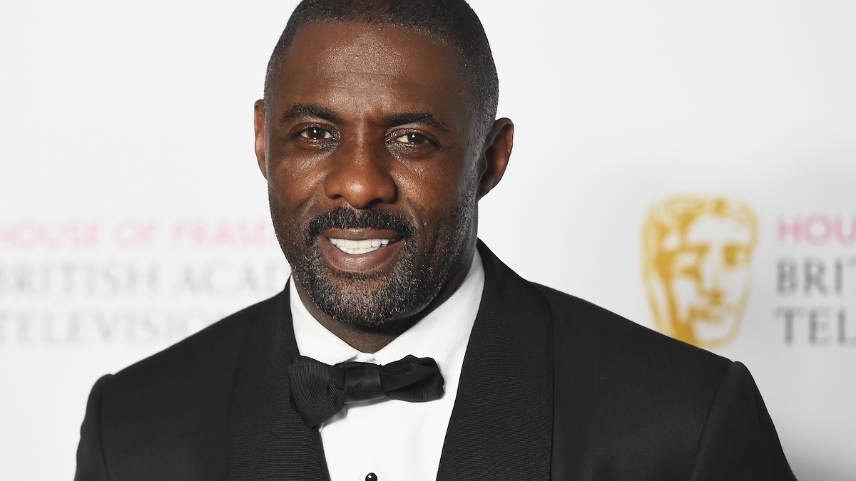 Idris Elba wearing a classic black tuxedo and bow tie at an awards event