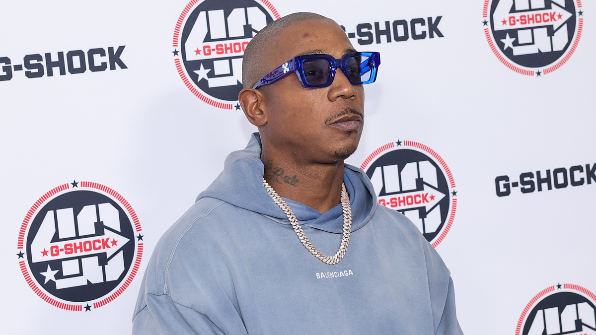 Man in blue hoodie and sunglasses stands in front of a G-SHOCK event backdrop